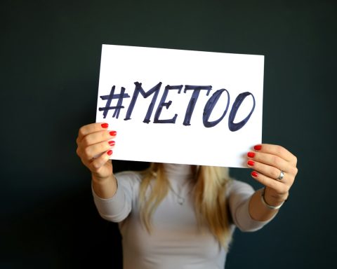 woman holding paper with metoo sign written