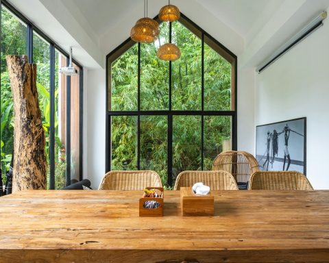 A large wooden table sitting in front of a window