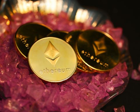 two gold coin sitting on top of a pile of pink crystals