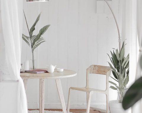 white steel chair in front round table on white rug