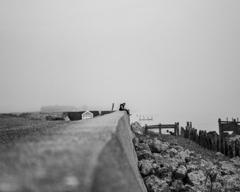 grayscale photo of people walking on the beach