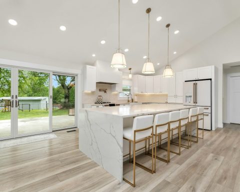 a large kitchen with a center island and marble counter tops