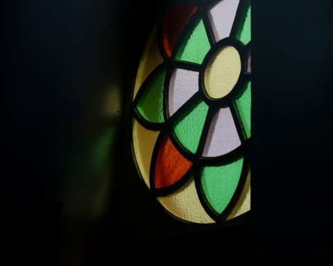 a stained glass window in a dark room