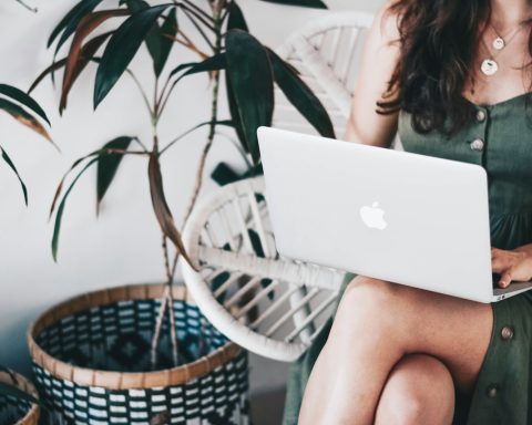 woman sitting and using MacBook