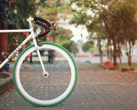 white and black city bike on brown brick floor during daytime