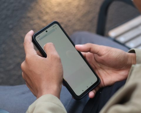 A person sitting on a bench using a cell phone