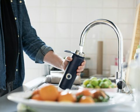 person holding stainless steel faucet