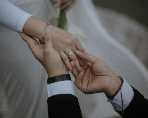 a bride and groom hold their hands together