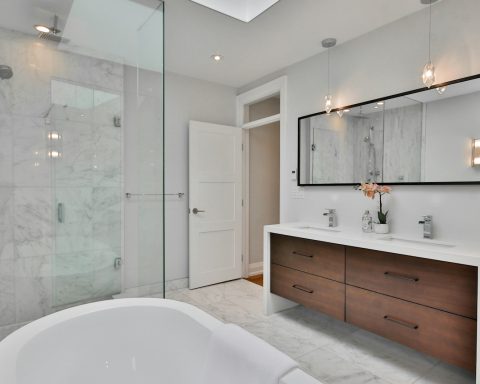 a bathroom with a large white bathtub next to a walk in shower