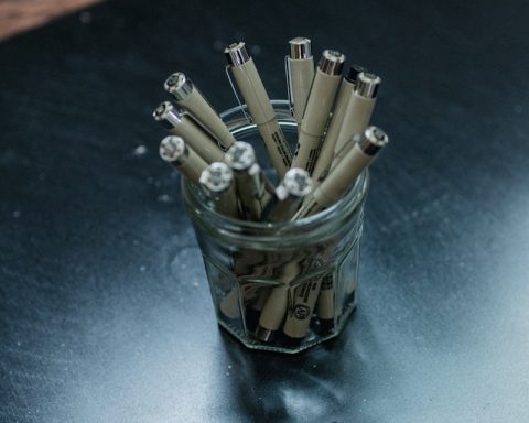 white pencils in black and white plastic cup