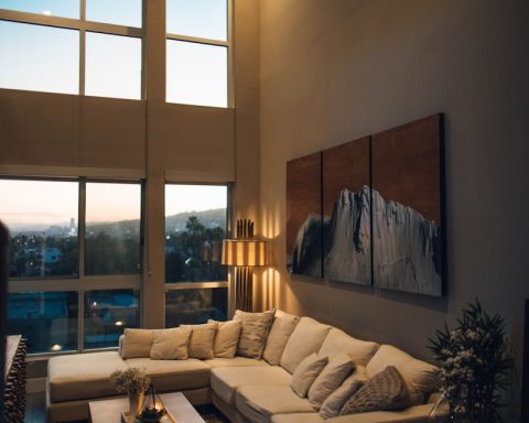 gray padded chaise couch beside window