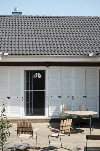 a patio with a table, chairs, and sliding doors