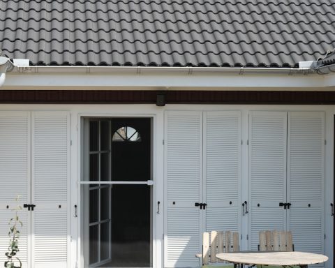 a patio with a table, chairs, and sliding doors