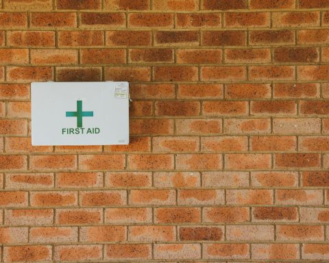 a first aid sign on a brick wall