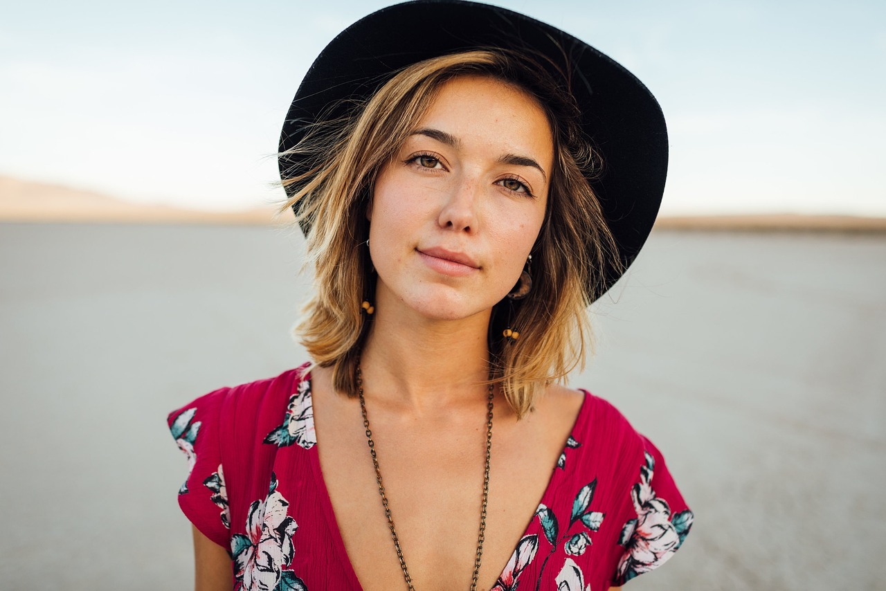 Vrouw met strohoed en zonnebril als zomerse accessoires op een terras
