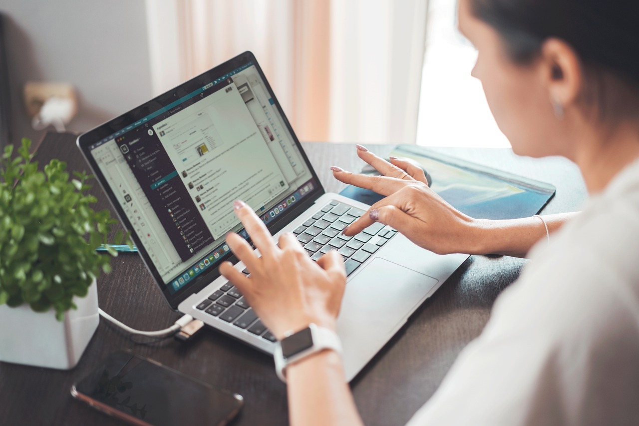 Vrouw werkt geconcentreerd achter laptop aan thuiswerkplek, bezig met financiële planning voor carrièreswitch