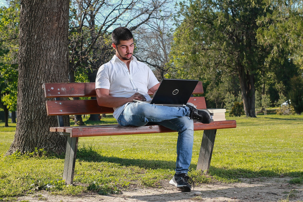 Persoon die in de zomer zijn financien doorneemt op een laptop