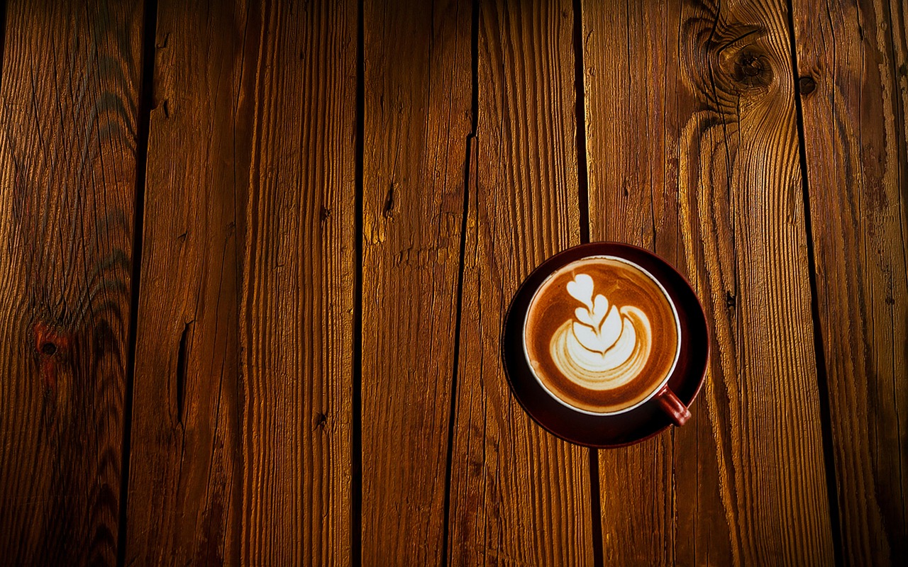 Reiziger werkt op laptop in een café met een kop koffie op tafel