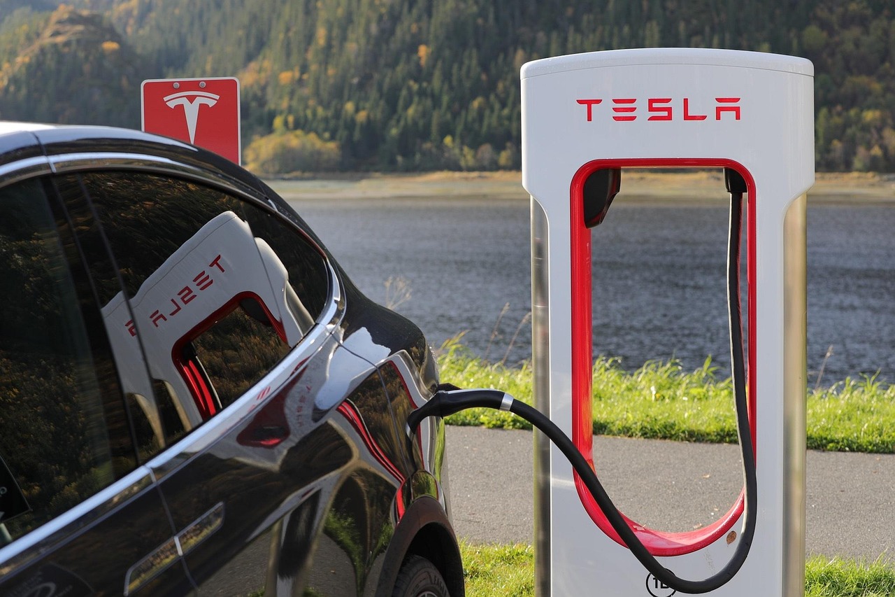 Elektrische auto die wordt opgeladen bij een snellaadstation langs de snelweg
