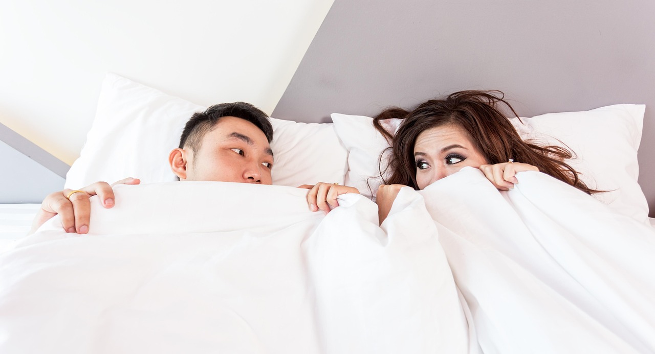 Twee aparte bedden in een lichte hotelkamer waar een koppel ontspannen wakker wordt op vakantie