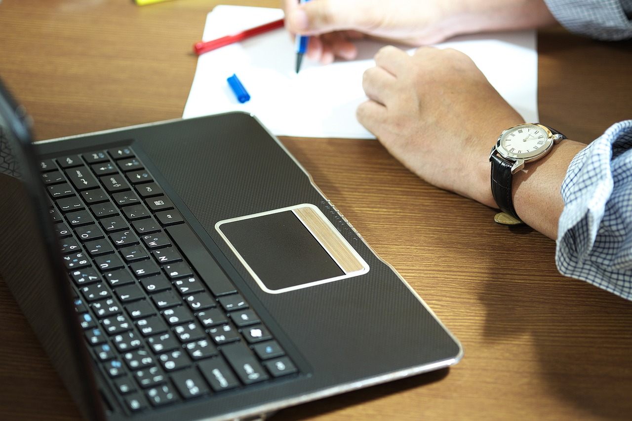 Zelfstandige aan bureau met verzekeringspapieren en laptop