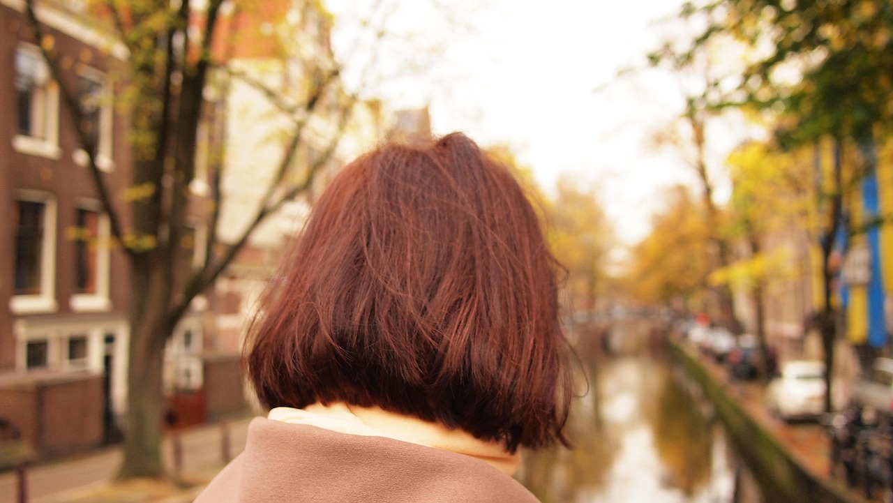 Vrouw past een herfstjas in een kledingwinkel